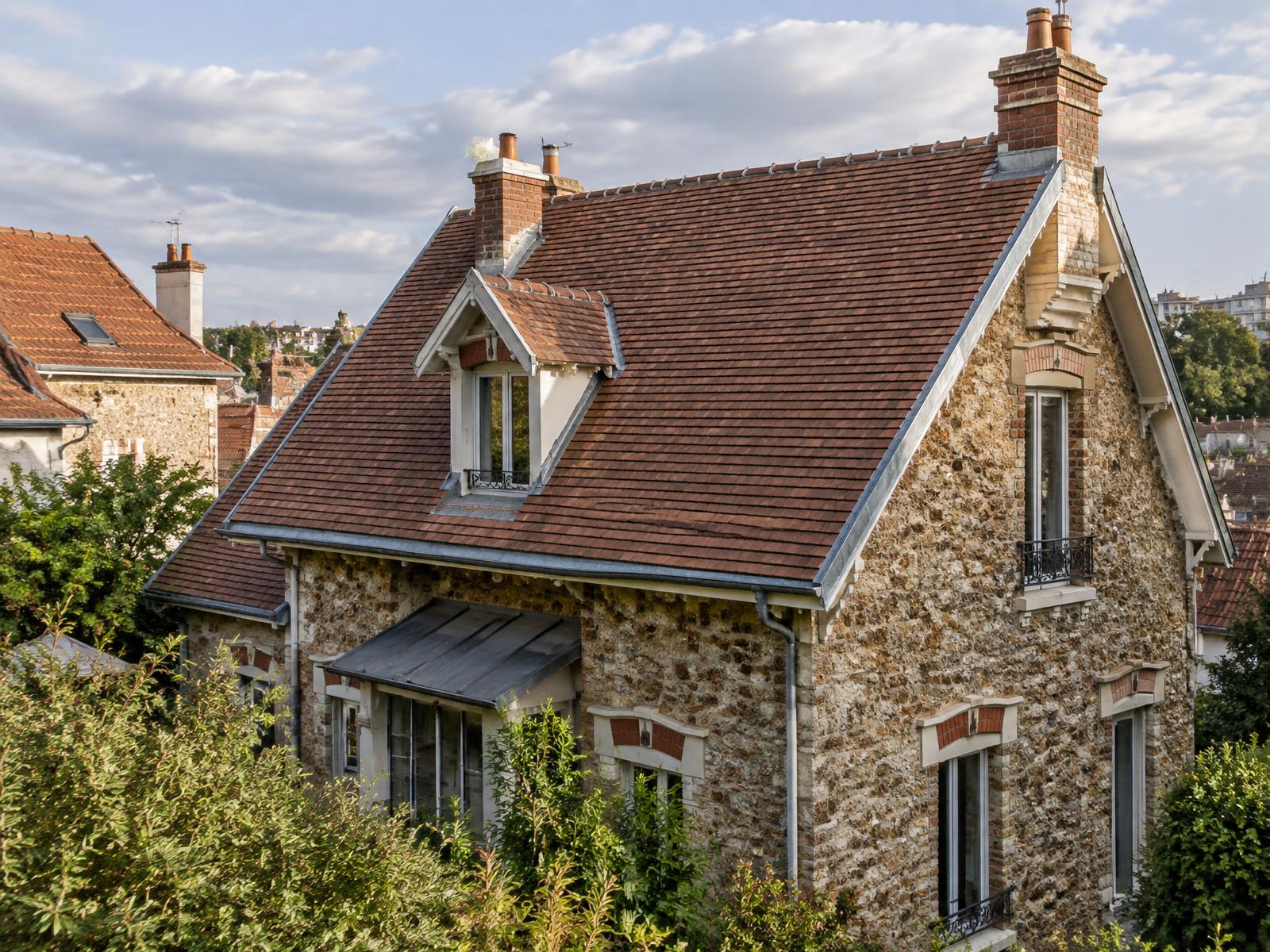 Pavillon francilien en meulière avec une toiture en tuiles plates entièrement refaite